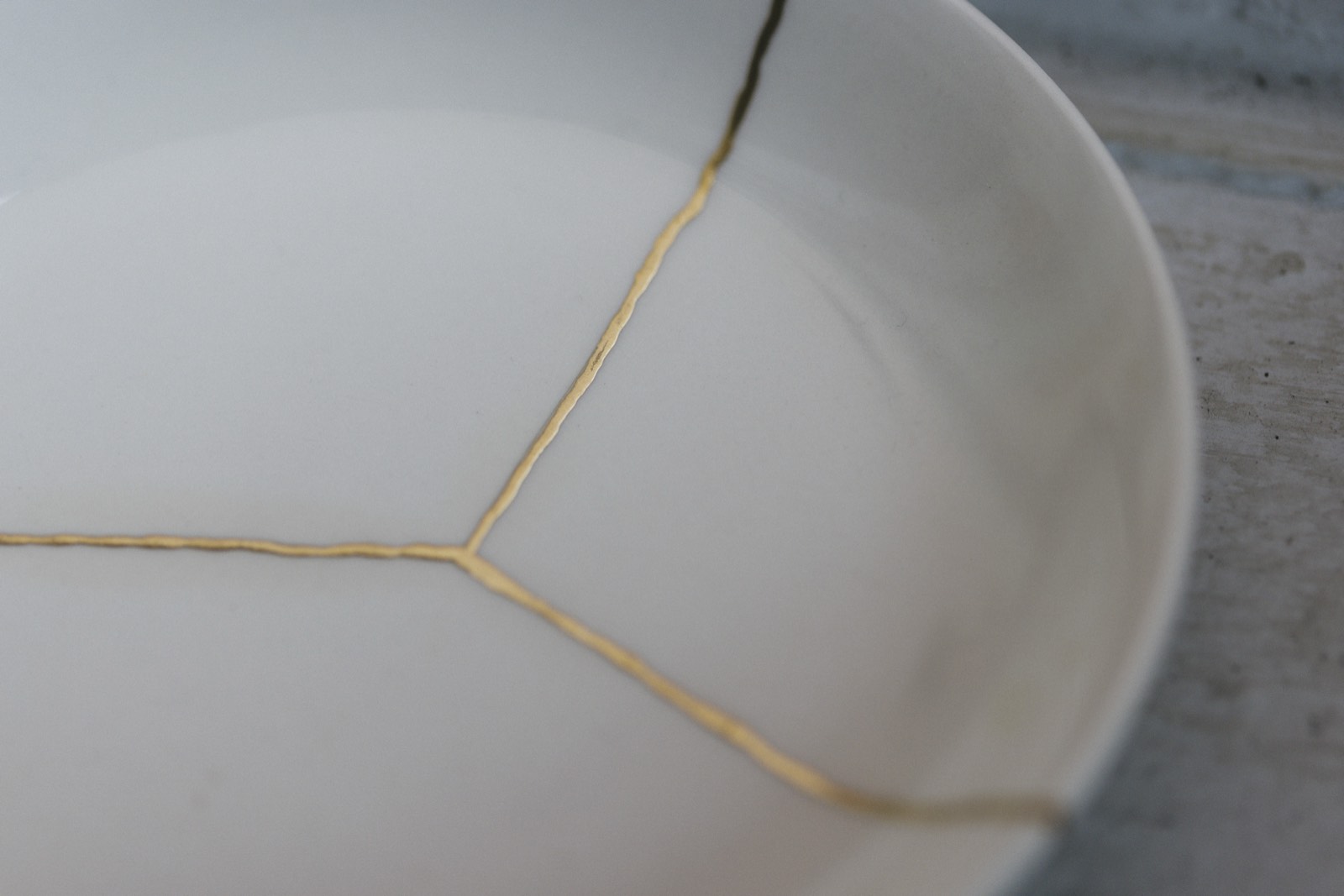 A white bowl mended with seams of gold